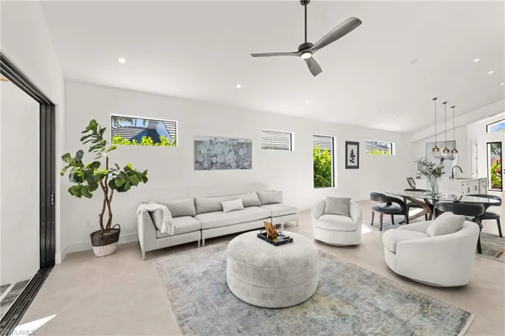 Living room with baseboards, a ceiling fan, and recessed lighting