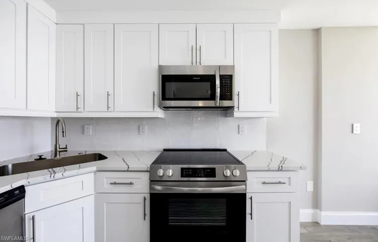 Remodeled kitchen with quartz countertops, stainless steel appliances, and tile backsplash.