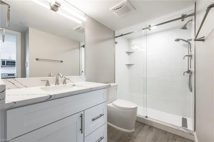 Fully renovated bathroom with tiled walk-in shower and glass enclosure