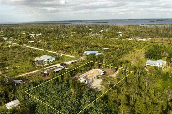 Looking East.  Surrounded by groves, this home offers excellent privacy while also being close to many of Pine Island's most desired amenities. Roof has been repaired since this photo was taken.