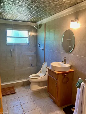 The guest bathroom has a unique tin ceiling and could easily accommodate a double vanity.