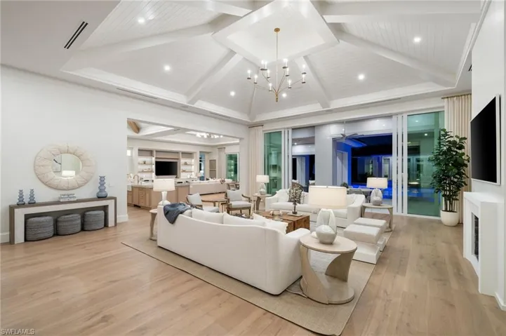 Great room featuring hardwood, an equisite chandelier, high vaulted ceiling, and stunning beam ceilings