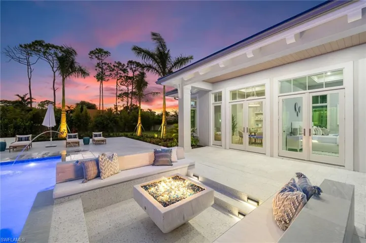Patio terrace at dusk featuring french doors and an outdoor fire pit - looking at the Guest House