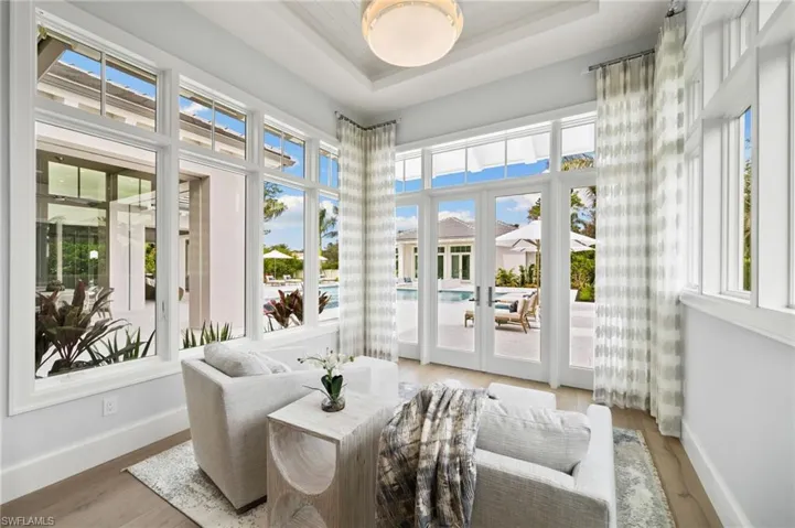 Sunroom off of Primary Suite, featuring french doors and a tray ceiling