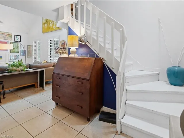 White painted wooden staircase with open risers and a partial blue accent wall