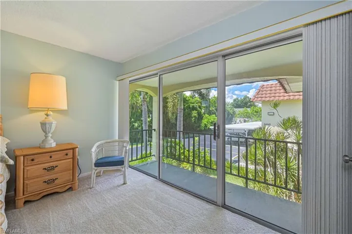 Wall-to-wall sliding glass doors open to a private covered balcony, bringing in abundant natural light and giving the primary suite its own outdoor retreat.
