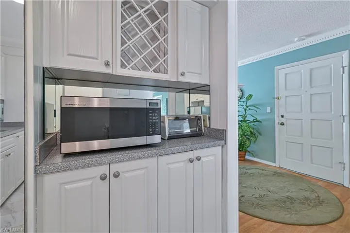 Additional built-in cabinetry provides extra storage and counter space, including a convenient wine rack and dedicated microwave area.