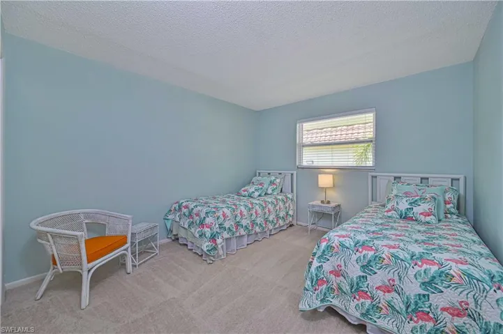 Spacious guest bedroom with two twin beds, comfortable carpeting and plenty of room for visiting family and friends.