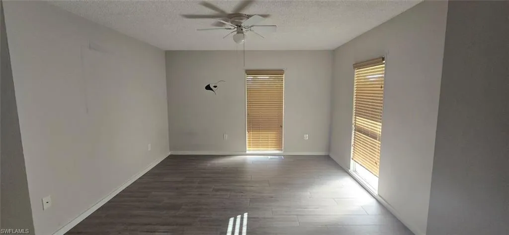 Unfurnished bedroom with dark wood-style floors, ceiling fan, and a textured ceiling