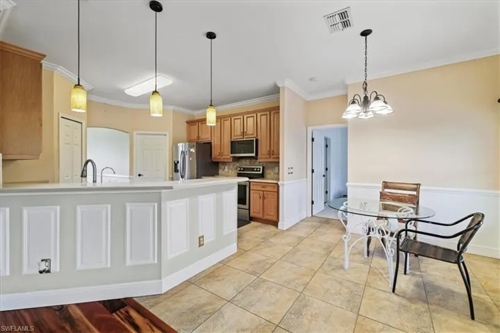 Unfurnished living room with wood finished floors, crown molding, arched walkways, and a ceiling fan