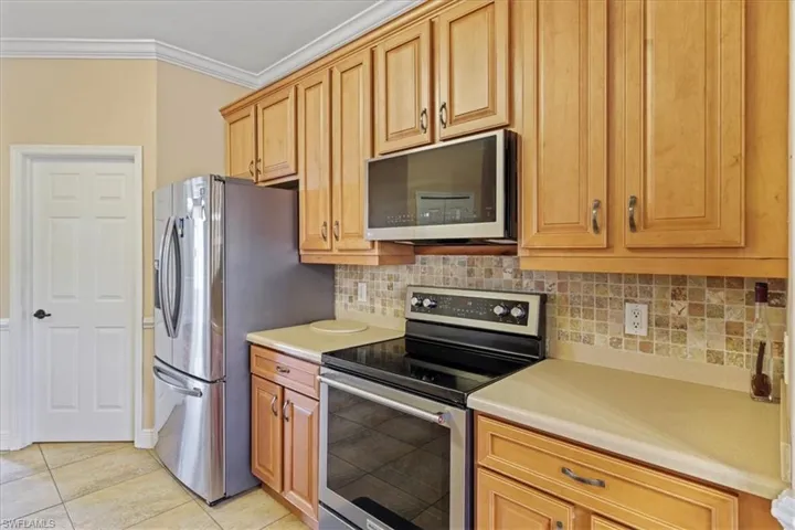 Spare room with arched walkways, wood finished floors, crown molding, and plenty of natural light