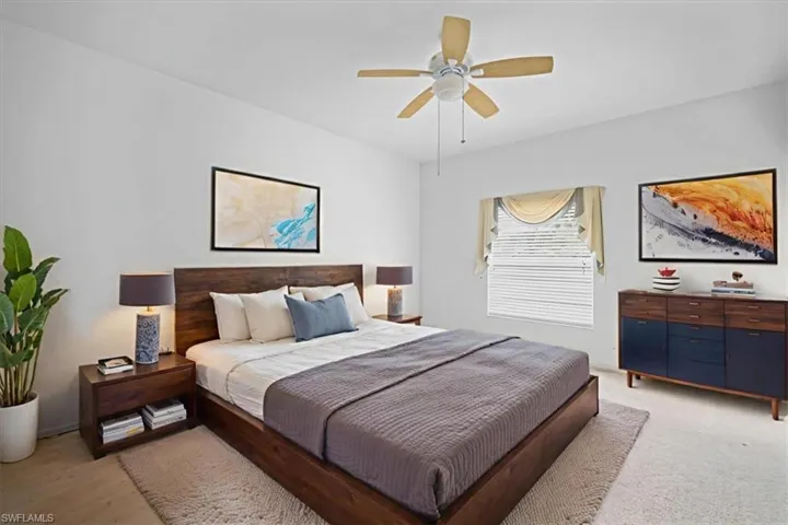 Bedroom with ceiling fan and light colored carpet