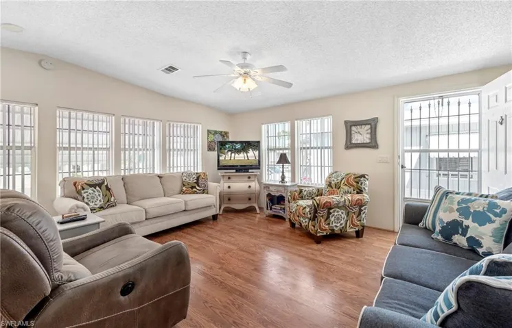 Living area featuring plenty of natural light, a textured ceiling, and wood finished floors