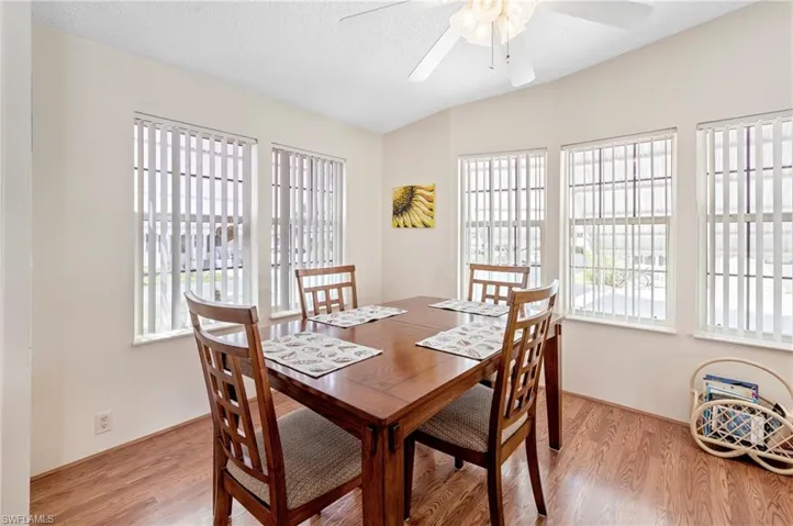 Dining room featuring a textured ceiling, ceiling fan, and light wood finished floors