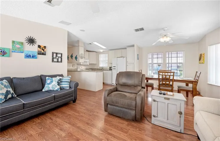 Living room with light wood-type flooring, plenty of natural light, and ceiling fan