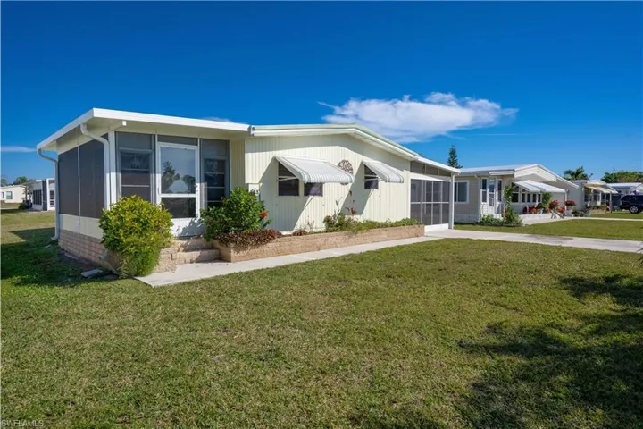 View of front of property featuring a front yard and a sunroom