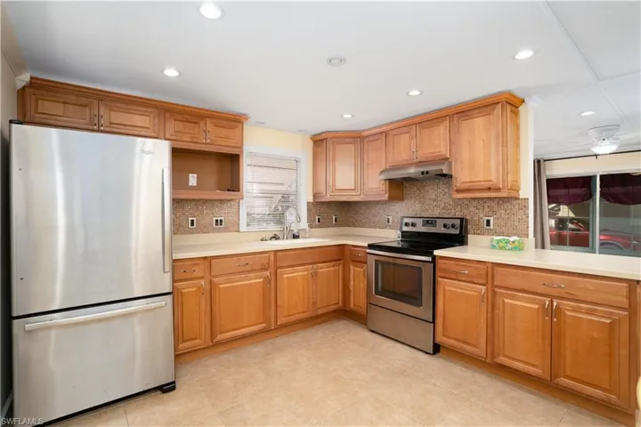 Kitchen featuring sink, decorative backsplash, and appliances with stainless steel finishes