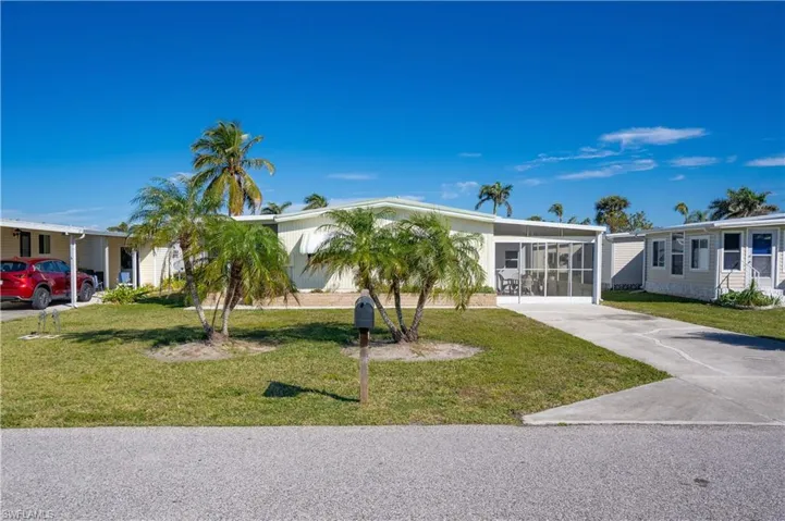 View of front of property featuring a front yard and a carport
