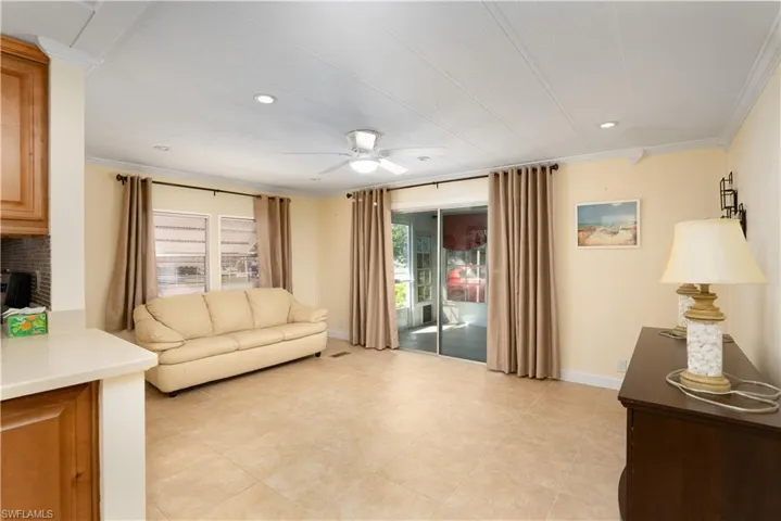 Living room with ornamental molding and ceiling fan