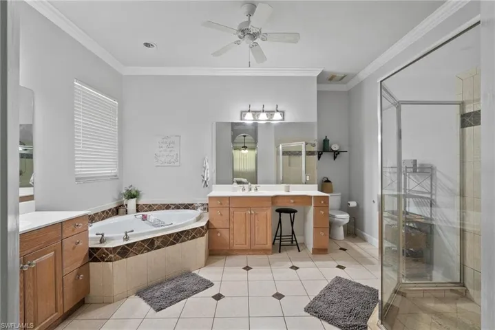 Full bathroom featuring crown molding, vanity, toilet, and ceiling fan