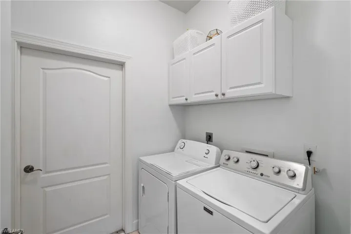 Laundry area featuring cabinets and washing machine and dryer