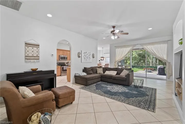 Living room with ceiling fan and light tile patterned floors