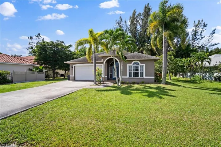 Mediterranean / spanish-style home featuring a garage and a front lawn