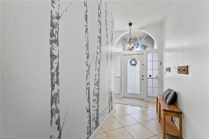 Tiled entryway with a chandelier