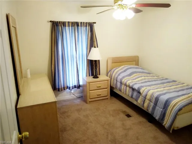 Bedroom with light colored carpet and a ceiling fan