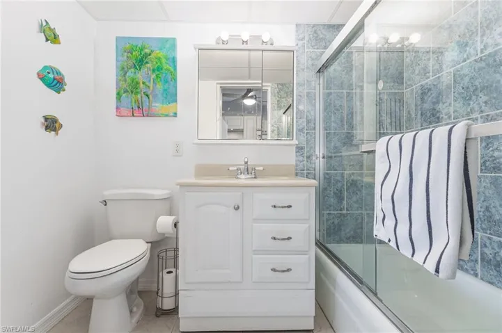 Full bathroom with vanity and bath / shower combo with glass door