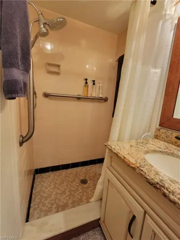 Bathroom with a shower with shower curtain, vanity, and a textured ceiling