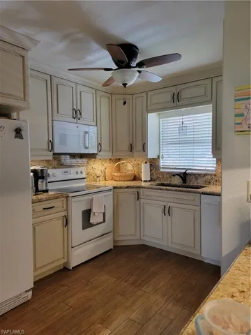 Kitchen with ceiling fan, fridge, range, dishwashing machine, and sink