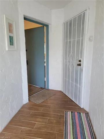 Hallway with hardwood / wood-style flooring