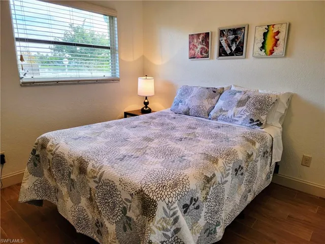 Bedroom with dark hardwood / wood-style flooring