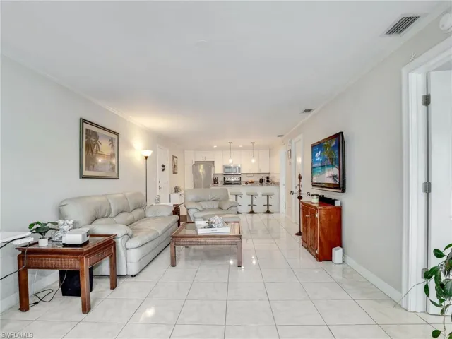 Living room featuring ornamental molding and light tile floors
