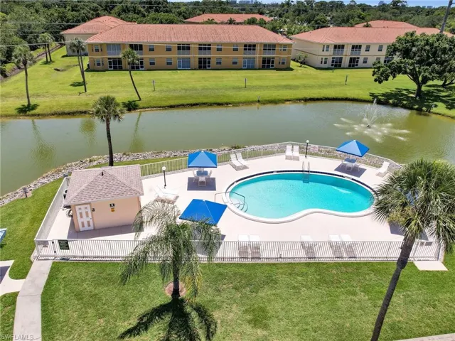 View of pool featuring a yard, a water view, and a patio