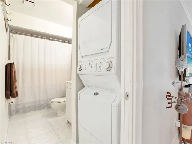 Bathroom featuring tile flooring, stacked washer and clothes dryer