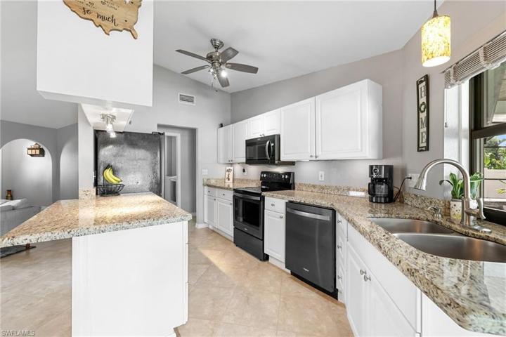 The kitchen boasts granite and black stainless steel appliances.