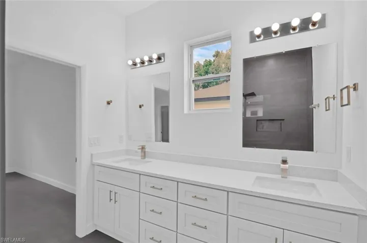 Full bath with double vanity and concrete floors