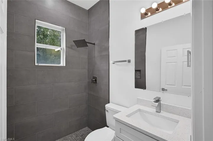 Full bath featuring vanity and a tile shower