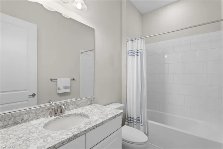 Full bath with shower / tub combo with curtain and vanity