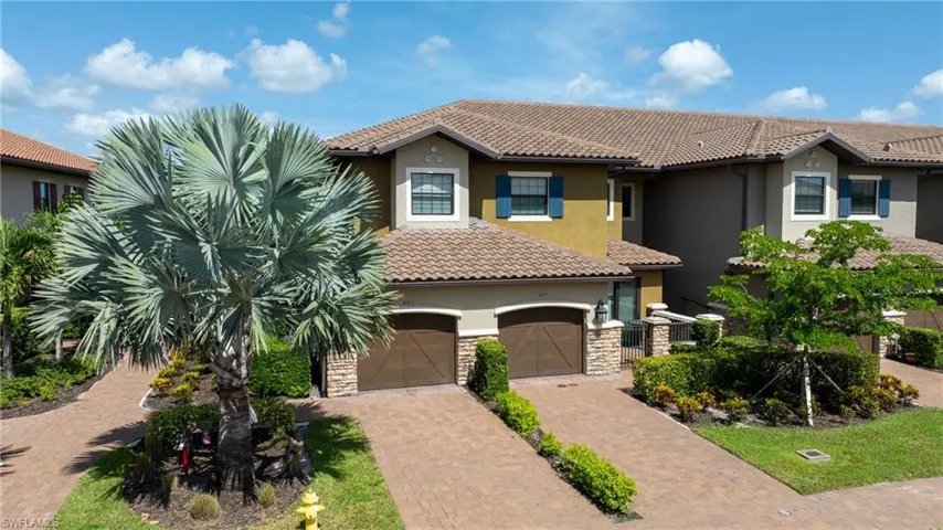 Mediterranean / spanish-style house with stucco siding, a tiled roof, decorative driveway, a garage, and stone siding