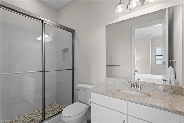Bathroom with vanity, a shower stall, and connected bathroom