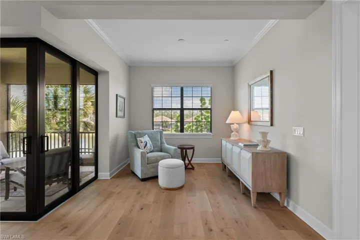 Living area featuring light wood-style flooring and ornamental molding