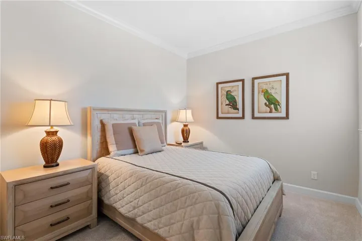 Bedroom with crown molding and light carpet