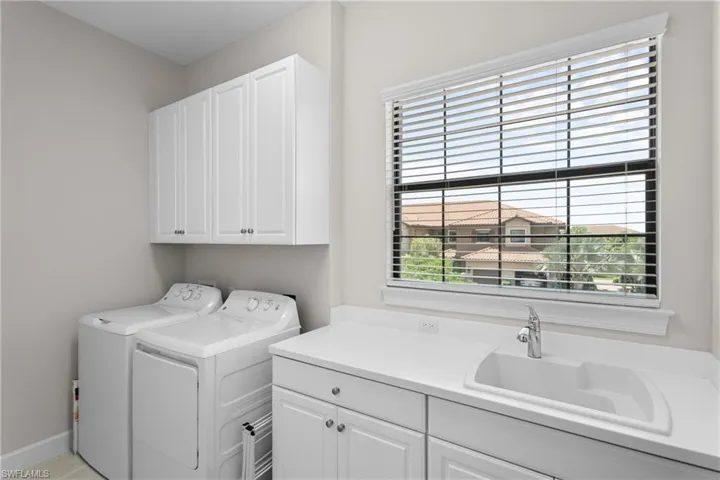 Laundry area with plenty of natural light, cabinet space, and washing machine and clothes dryer