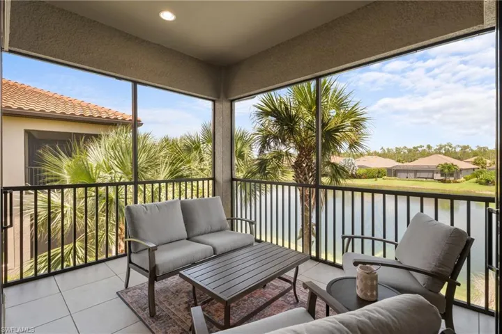 Sunroom with a balcony, a water view, and outdoor lounge area