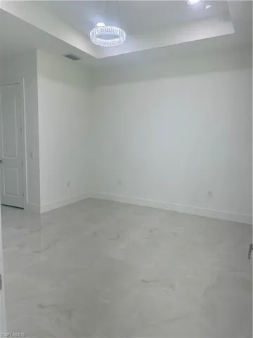 Spare room with tile patterned flooring and a tray ceiling