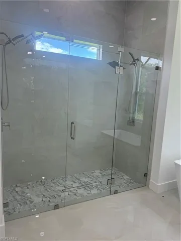 Bathroom featuring a shower with shower door and tile patterned floors