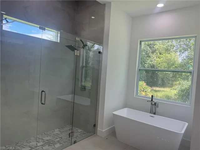 Bathroom with a shower with shower door and tile patterned floors